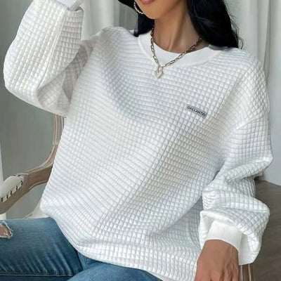White textured pullover sweatshirt with drop shoulders, paired with jeans, on a model showcasing casual style.