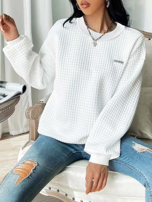 White drop shoulder sweatshirt with textured fabric, styled with ripped jeans, perfect for casual outfits.