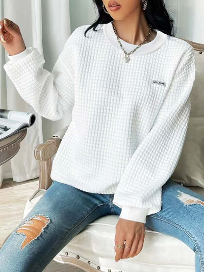 White drop shoulder sweatshirt with textured fabric, styled with ripped jeans, perfect for casual outfits.