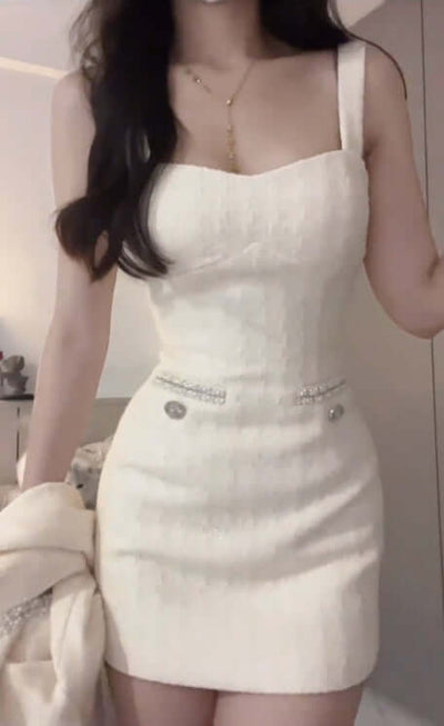 Model wearing a stylish white evening dress with spaghetti straps and decorative buttons.