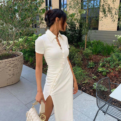 Model wearing a stylish Women's Shirt Collar Button Bevel Slit Dress in white, highlighted by a chic garden backdrop.