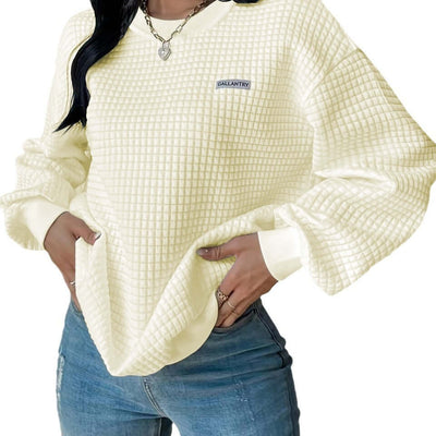Loose drop shoulder sweatshirt in cream color with textured fabric and logo detail, perfect for casual style.